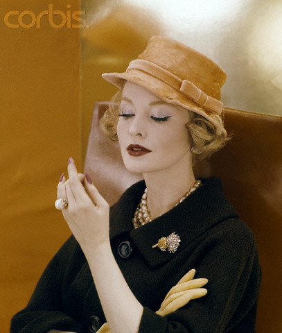 Model purtand o palarie Adolo of Emme si o brosa verdura, fotografiata de Henry Clarke in 1959